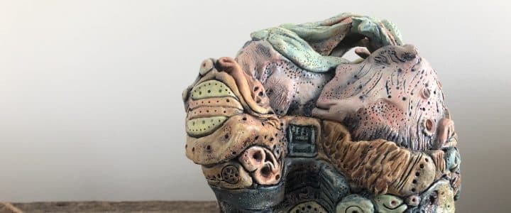 Poterie (vase en poterie sculptée multicolore avec différents motifs par Joan Marilyn Moore Tierney sur table de bois variés)