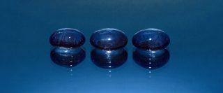 Trois pierres de verre bleu qui représentent les trois lignes de syllabes du poème haïku.