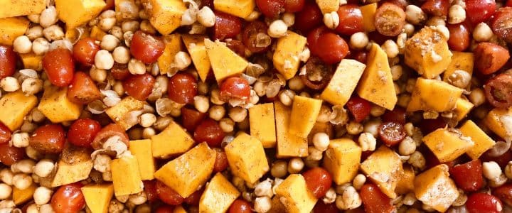 Gros plan sur des pois chiches, tomates et courges coupés en dés pour cuisson végétarienne.