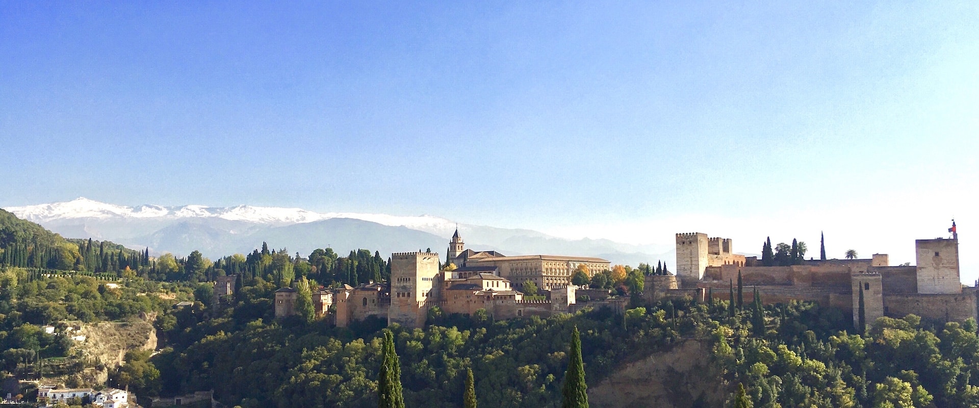 Vue sur l'Alhambra de Grenade avec les pics blancs de la Sierra Nevada en arrière-plan.