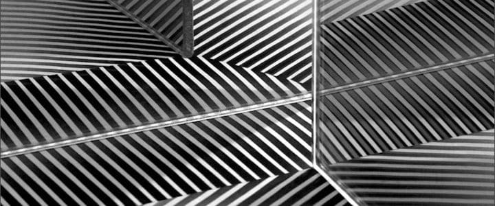 Reflets en noir et blanc d’une feuille de papier avec rayures dans plusieurs miroirs