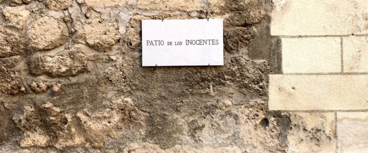 Plaque Los Inocentes sur un mur de pierres beiges à l'université de Granada en Espagne.