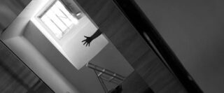 un bras et un escabeau dans un appartement avec prise de vue à angle