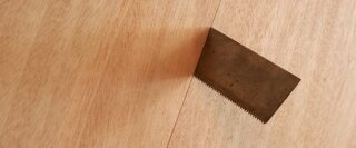 Une scie qui dépasse au-dessus d’une planche de bois.