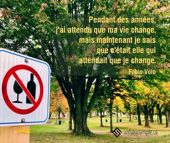 Citation de Fabio Volo: Pendant des années, j'ai attendu que ma vie change, mais maintenant je sais que c'était elle qui attendait que je change. Affiche boisson interdite devant un parc avec un gros arbre.
