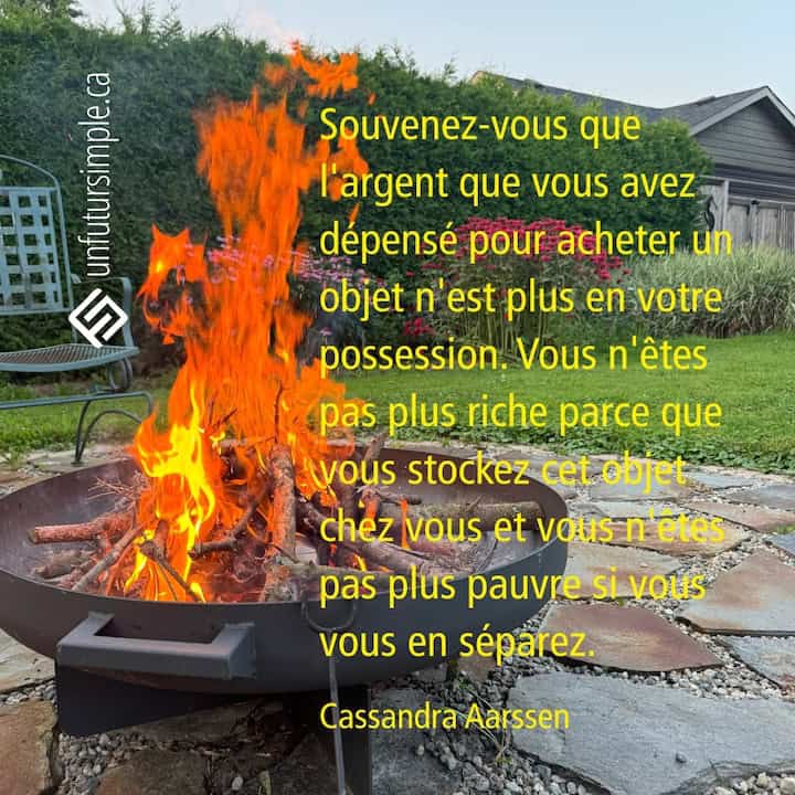 Citation de Cassandra Aarssen: Souvenez-vous que l'argent que vous avez dépensé pour acheter un objet n'est plus en votre possession. Vous n'êtes pas plus riche parce que vous stockez cet objet chez vous et vous n'êtes pas plus pauvre si vous vous en séparez. Feu dans un foyer extérieur dans une cour avec haie et plate-bande de fleurs.